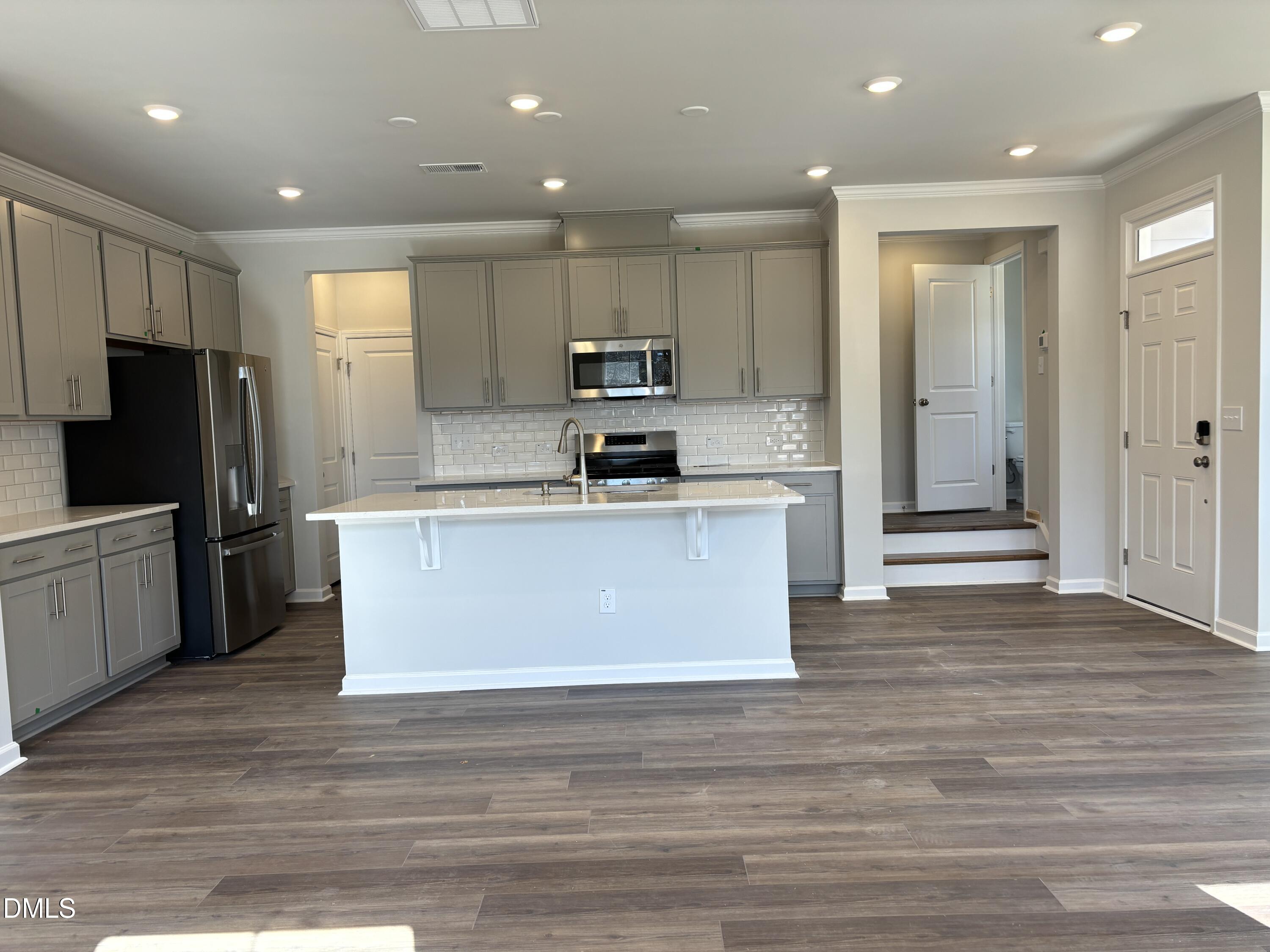 2011 Rabbit Hop Trail Apex, NC 27502 - Photo 2 of 27 a kitchen with stainless steel appliances kitchen island granite countertop a stove a sink and a refrigerator