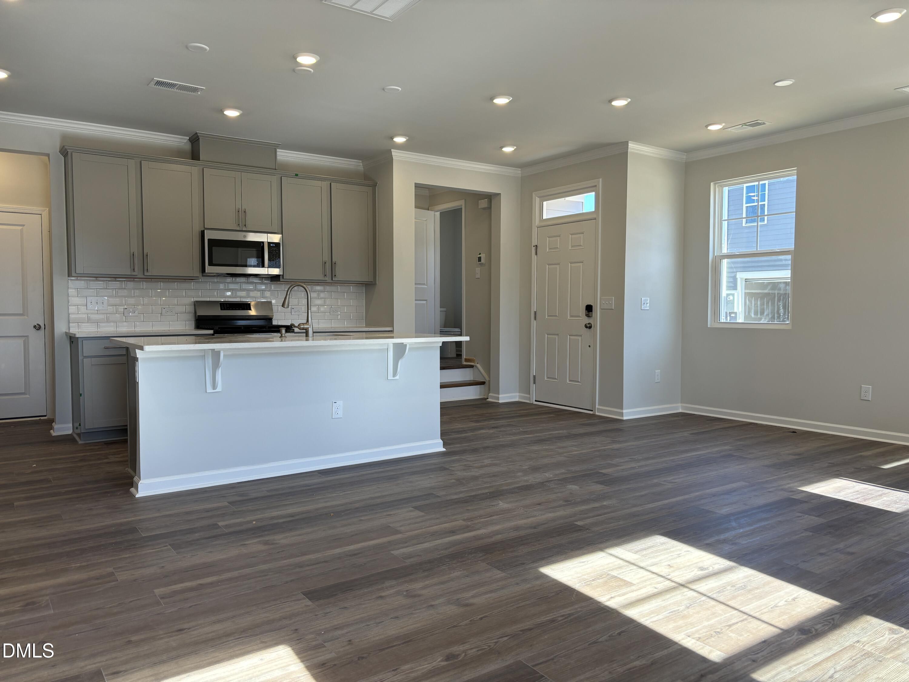 2011 Rabbit Hop Trail Apex, NC 27502 - Photo 3 of 27 a large kitchen with stainless steel appliances granite countertop a stove a sink and a wooden floors