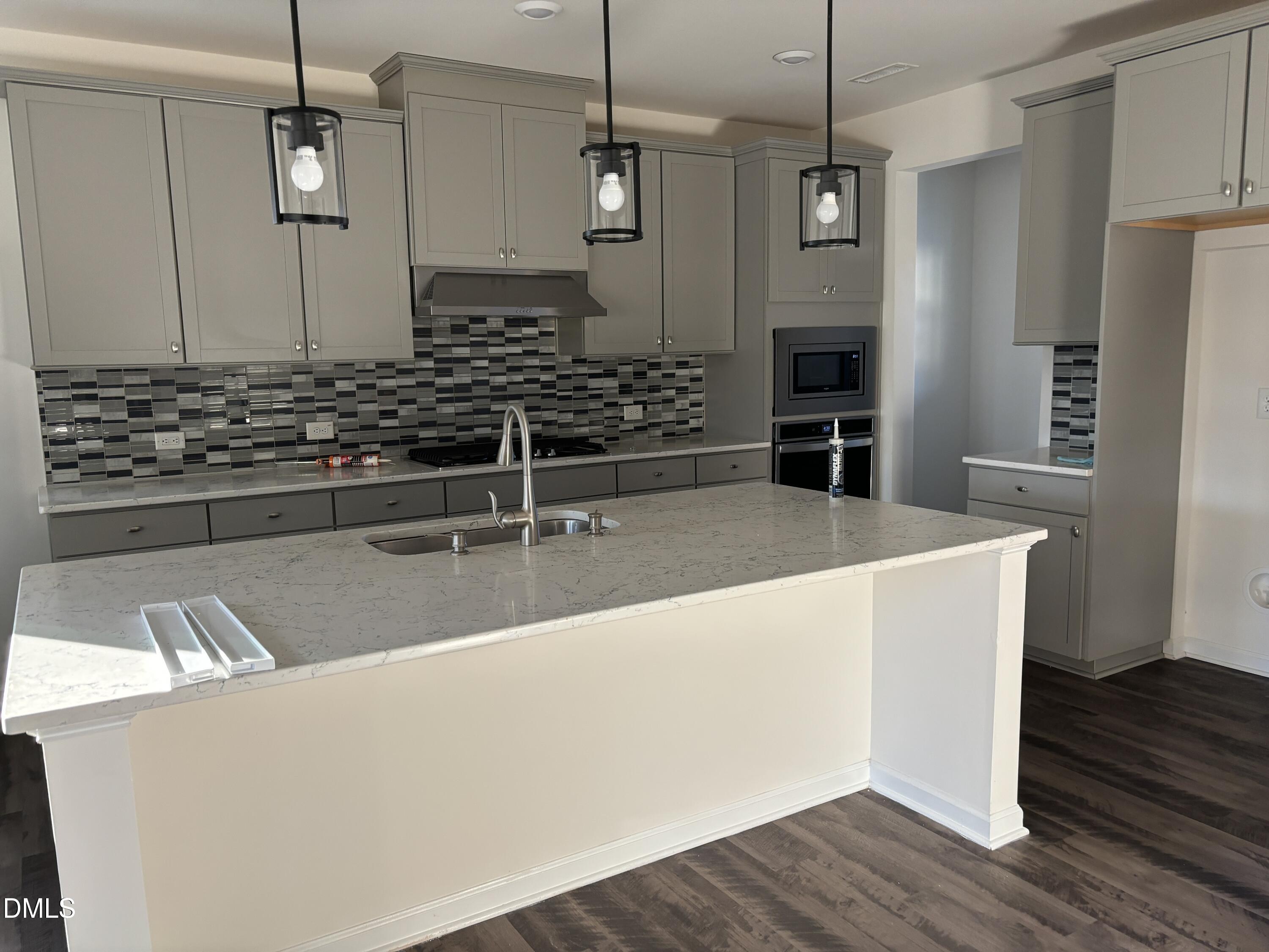 2011 Rabbit Hop Trail Apex, NC 27502 - Photo 4 of 27 a kitchen with stainless steel appliances granite countertop a sink and wooden floor