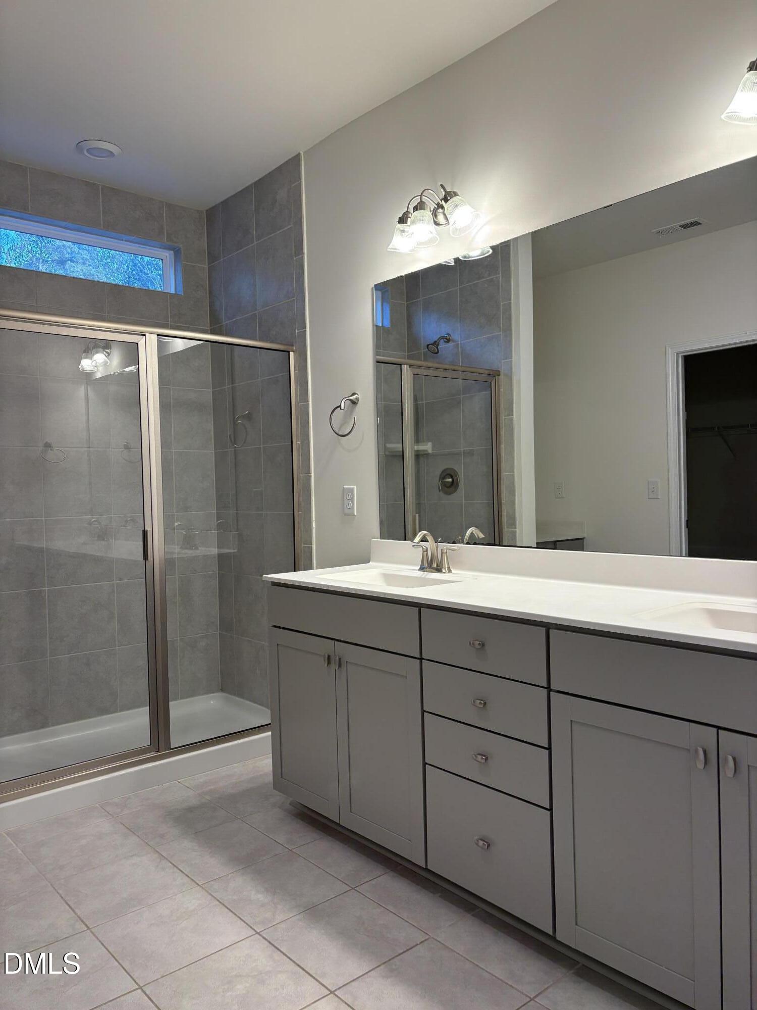 2011 Rabbit Hop Trail Apex, NC 27502 - Photo 6 of 27 a bathroom with a double vanity sink and mirror