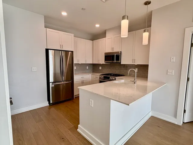 a kitchen with a sink a refrigerator a microwave and cabinets
