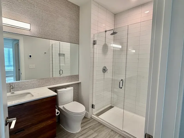 a bathroom with a sink a toilet and shower