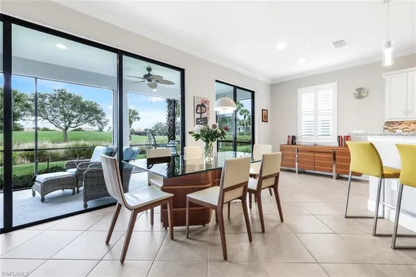 a dining room with furniture and a floor to ceiling window