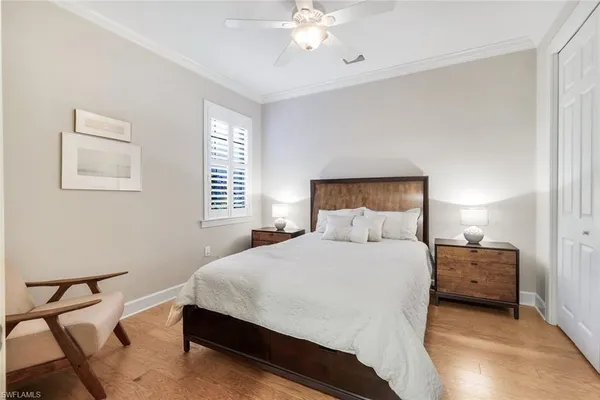 a bedroom with a bed a chandelier and a chair