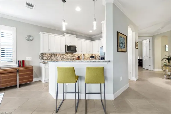 a kitchen with kitchen island granite countertop a sink and cabinets