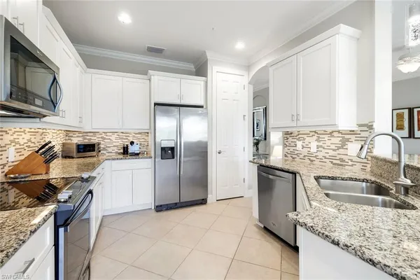 a kitchen with stainless steel appliances granite countertop a refrigerator stove microwave and sink