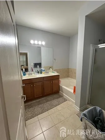 a bathroom with a tub a sink and a large mirror