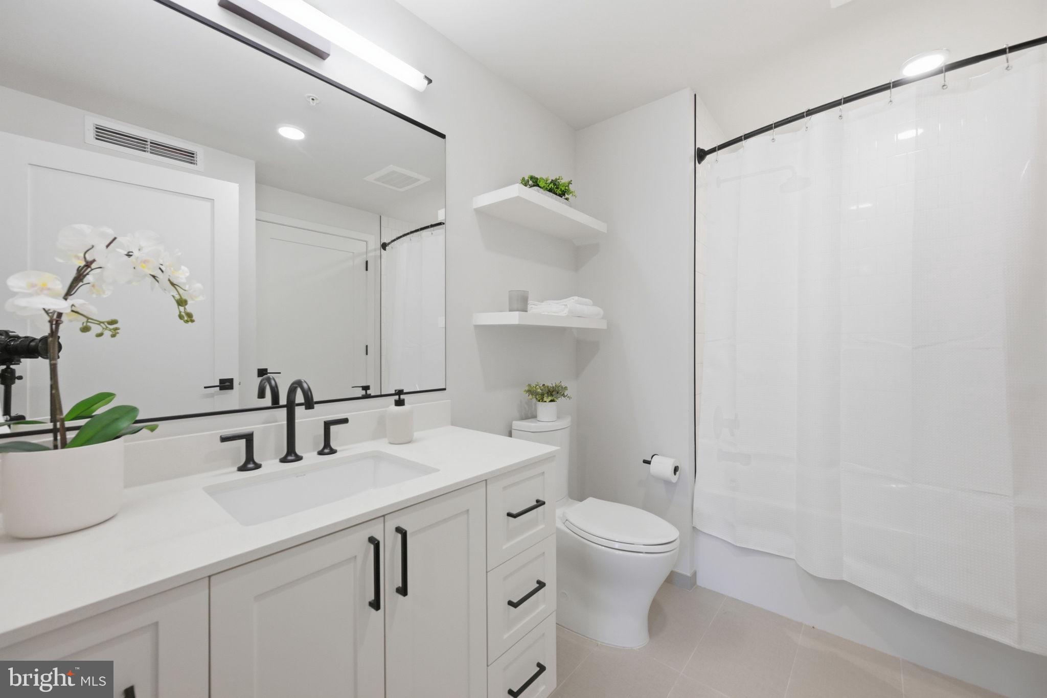 1211 Van Street Southeast, Unit 1007 Washington, DC 20003 - Photo 13 of 21 a bathroom with a sink a toilet and a mirror