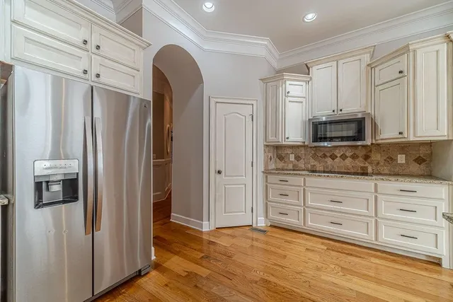 a view of an empty room with wooden floor fireplace and a window