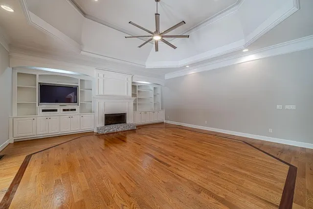 an empty room with windows and fan