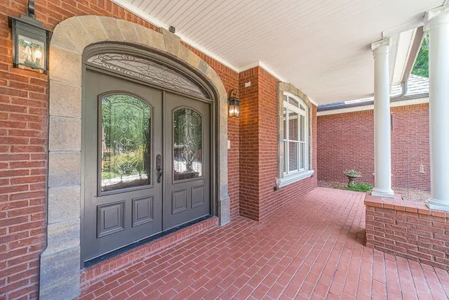 an empty room with wooden floor a ceiling fan and windows