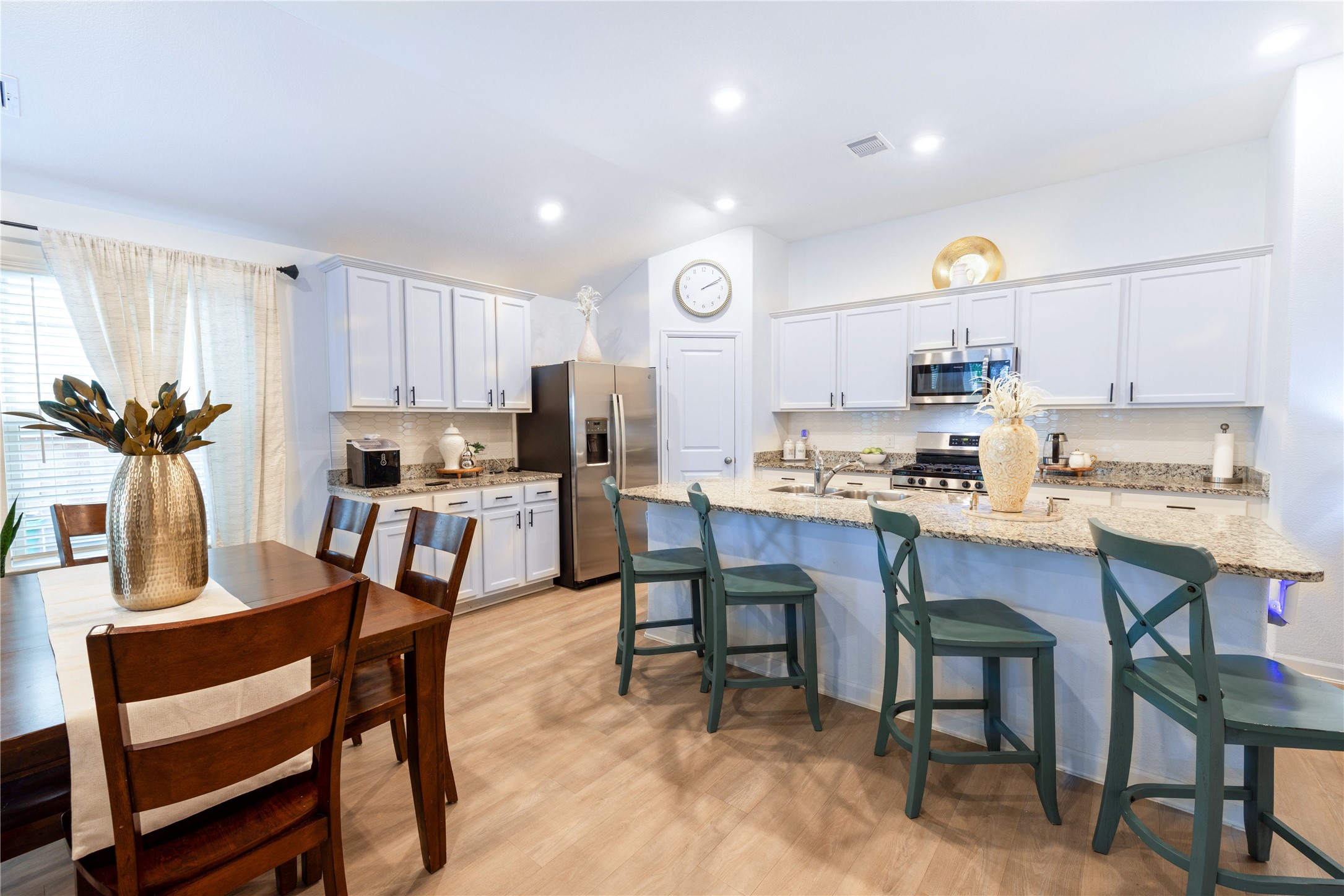 5715 Prairie Chapel Road Katy, TX 77493 - Photo 7 of 30 a kitchen with a dining table chairs refrigerator and cabinets