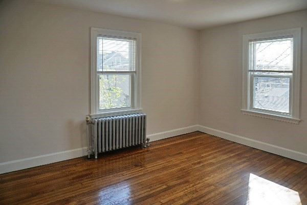 95 Adams Street, Unit 9 Waltham, MA 02453 - Photo 5 of 8 a view of an empty room with wooden floor and a window