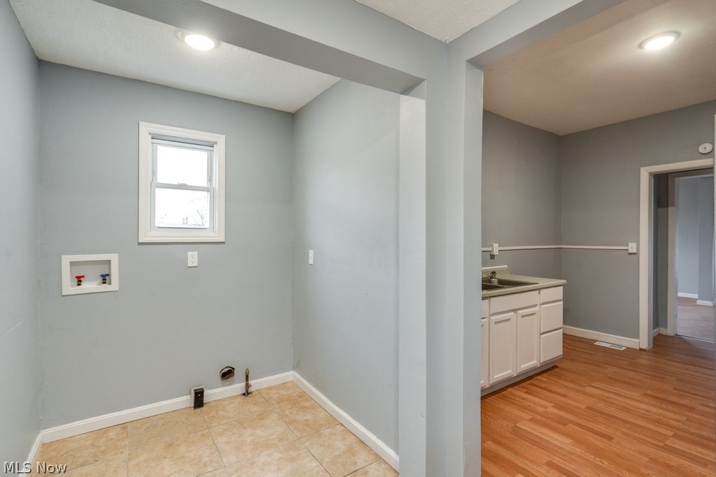 1607 9th Street Southwest Canton, OH 44706 - Photo 23 of 41 Laundry area with tile flooring, a window, and hookups for appliances