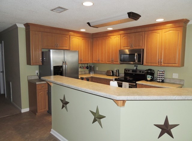 627 Old Cabaniss Road Forsyth, GA 31029 - Photo 3 of 20 a kitchen with stainless steel appliances granite countertop a refrigerator a stove and a sink with wooden floor