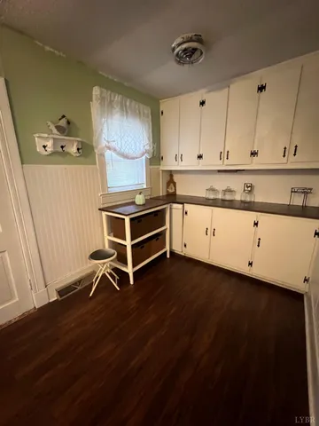 a kitchen with granite countertop a stove and a wooden floor