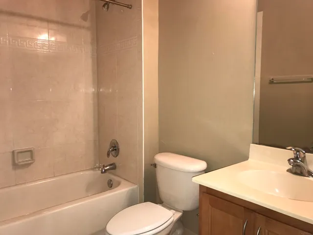 a view of an empty room with wooden floor and closet