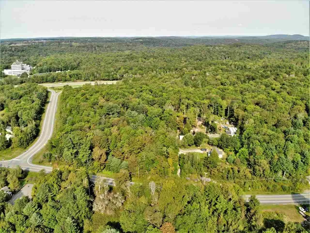 an aerial view of residential houses with outdoor space and trees