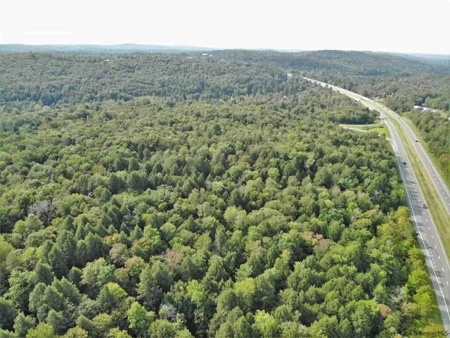 an aerial view of residential houses with outdoor space and trees