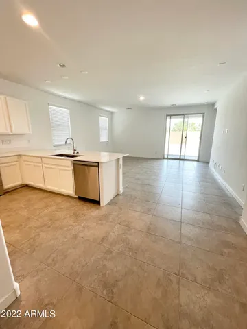 a view of kitchen with refrigerator sink and cabinets
