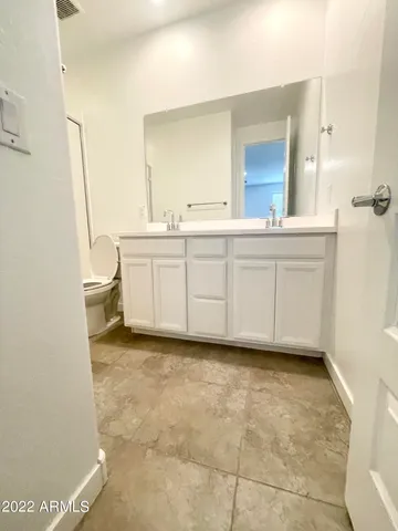 a bathroom with a double vanity sink toilet and shower