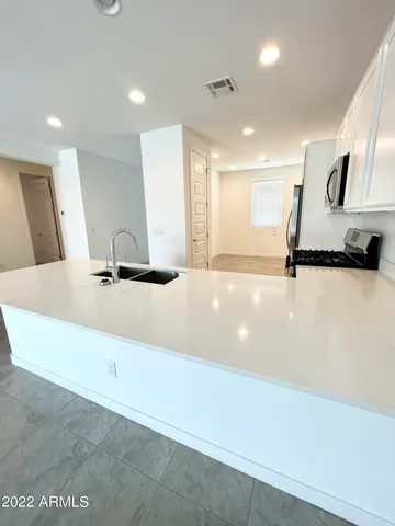 a kitchen with stainless steel appliances granite countertop a refrigerator a stove a sink and a microwave