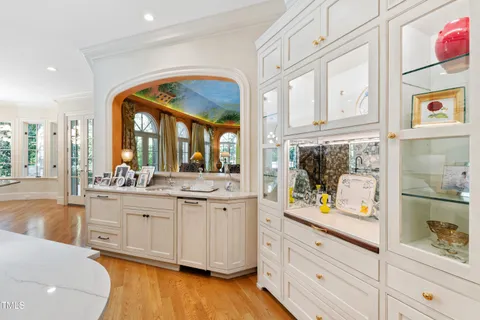 a living room with furniture kitchen area and a large window