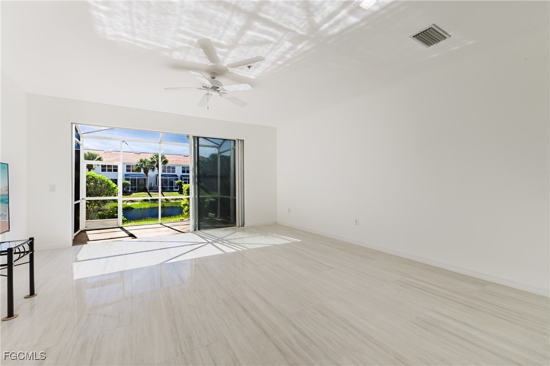 827 Hampton Circle, Unit 146 Naples, FL 34105 - Photo 11 of 36 a view of an empty room with a window and wooden floor