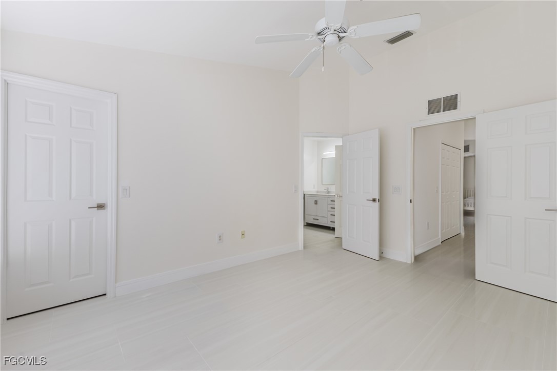 827 Hampton Circle, Unit 146 Naples, FL 34105 - Photo 19 of 36 an empty room with a ceiling fan and bathroom