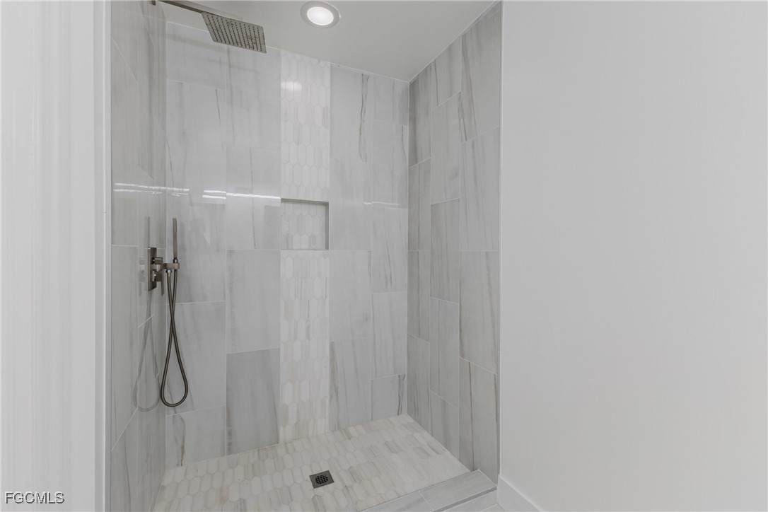 827 Hampton Circle, Unit 146 Naples, FL 34105 - Photo 21 of 36 a bathroom with a glass shower door