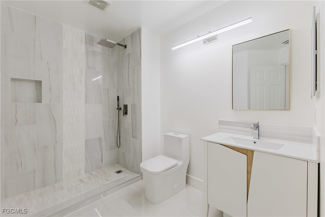827 Hampton Circle, Unit 146 Naples, FL 34105 - Photo 26 of 36 a bathroom with a toilet a sink and shower