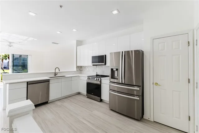 a kitchen with granite countertop stainless steel appliances and wooden floor
