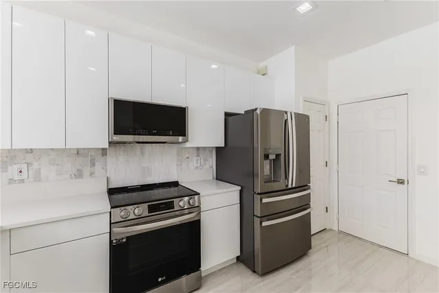 a kitchen with stainless steel appliances a refrigerator a stove a microwave and cabinets