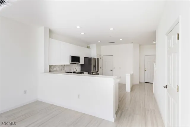 a view of a kitchen with stainless steel appliances wooden floor and a window