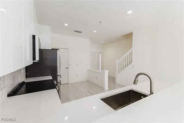 a view of a kitchen with a sink and refrigerator