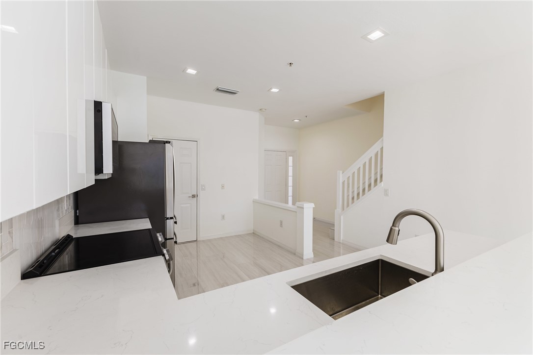 827 Hampton Circle, Unit 146 Naples, FL 34105 - Photo 9 of 36 a view of a kitchen with a sink and refrigerator