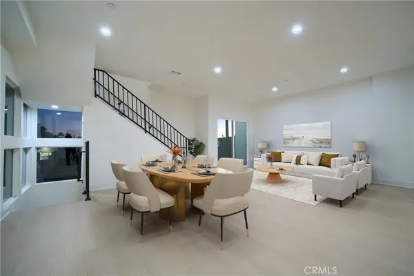 a kitchen with stainless steel appliances kitchen island granite countertop a dining table chairs refrigerator and sink