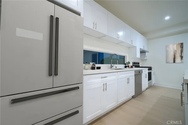 a kitchen with white cabinets and white appliances