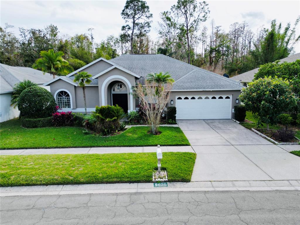 a front view of a house with a garden and plants
