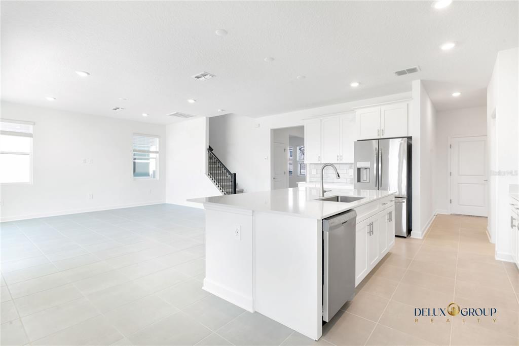 2947 Believe In Yourself Court Clermont, FL 34714 - Photo 14 of 50 a kitchen with stainless steel appliances kitchen island granite countertop a refrigerator a sink a stove and white cabinets with wooden floor