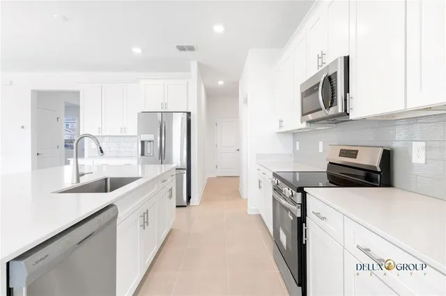 a kitchen with stainless steel appliances kitchen island a sink stove and refrigerator