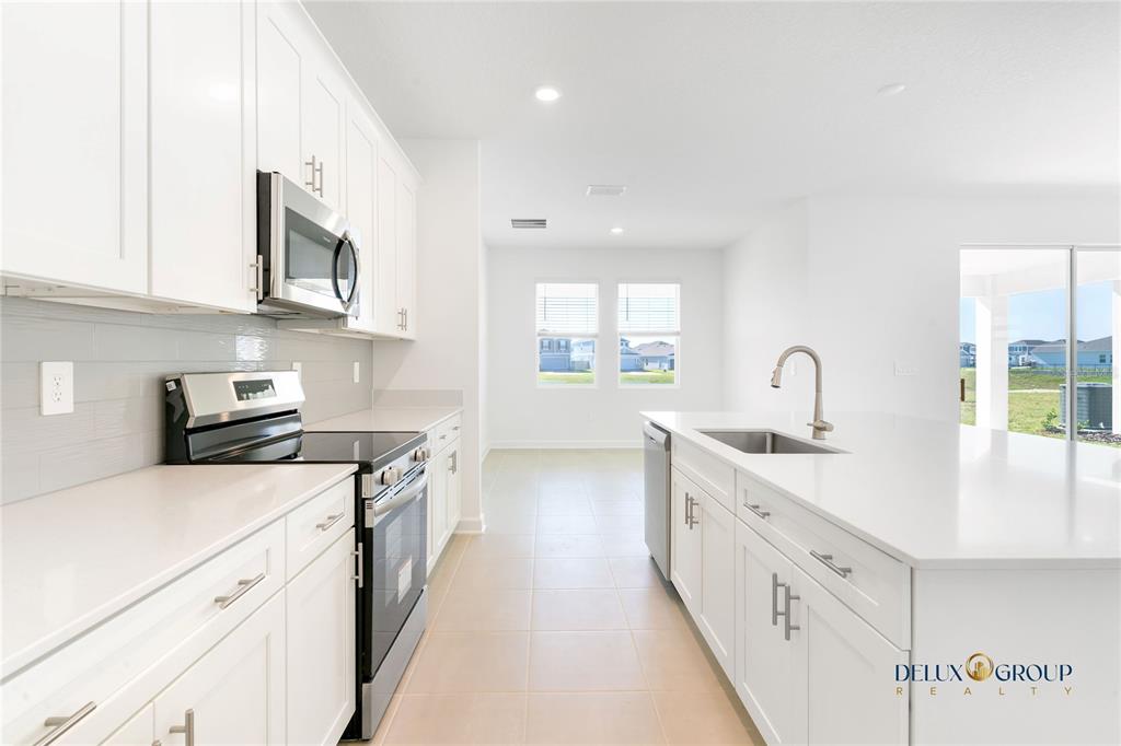 2947 Believe In Yourself Court Clermont, FL 34714 - Photo 16 of 50 a kitchen with white cabinets appliances and a sink