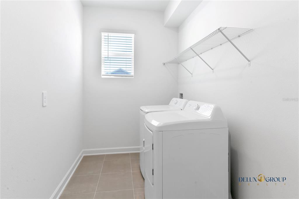 2947 Believe In Yourself Court Clermont, FL 34714 - Photo 18 of 50 a utility room with a sink dryer and chandelier