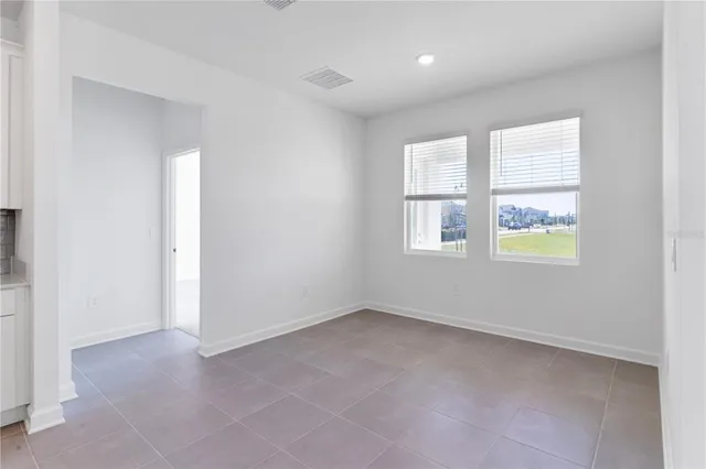 an empty room with staircase and windows