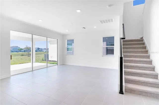 a view of kitchen with stainless steel appliances kitchen island large window and wooden floor