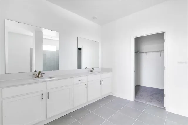 a spacious bathroom with a double vanity sink and a mirror