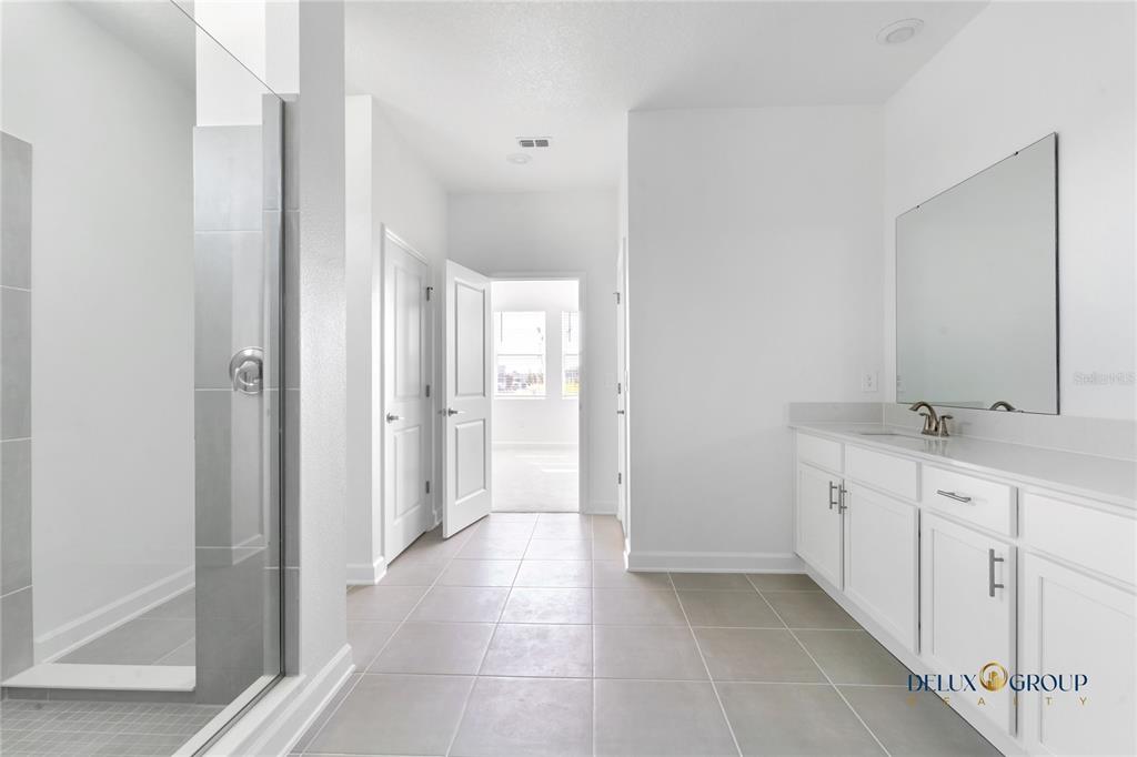 2947 Believe In Yourself Court Clermont, FL 34714 - Photo 30 of 50 a spacious bathroom with a double vanity sink and a mirror
