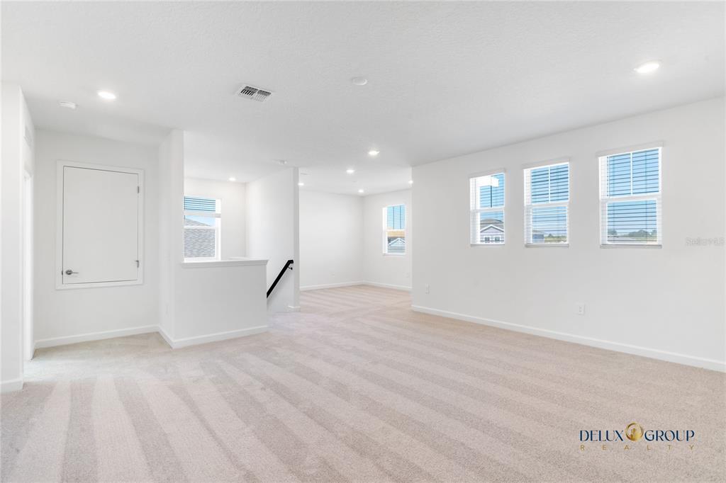 2947 Believe In Yourself Court Clermont, FL 34714 - Photo 37 of 50 a view of an empty room with wooden floor and windows