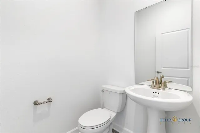 a white toilet sitting next to a white sink