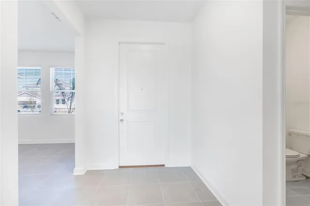 a large white kitchen with stainless steel appliances granite countertop a stove a sink a refrigerator and white cabinets with wooden floor